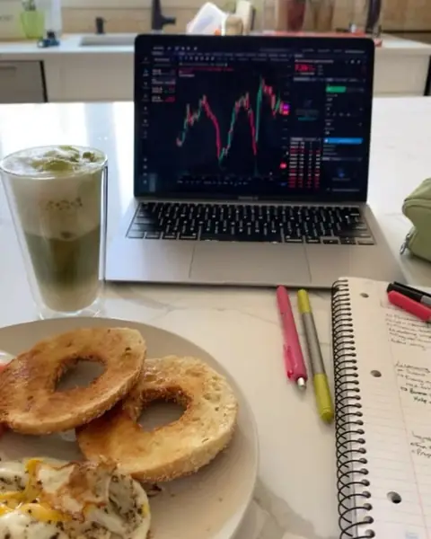 Breakfast next to a laptop showing a trading chart